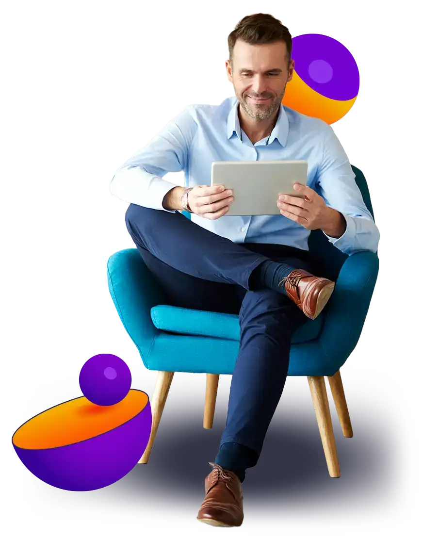 Man sitting on a chair looking at a tablet.