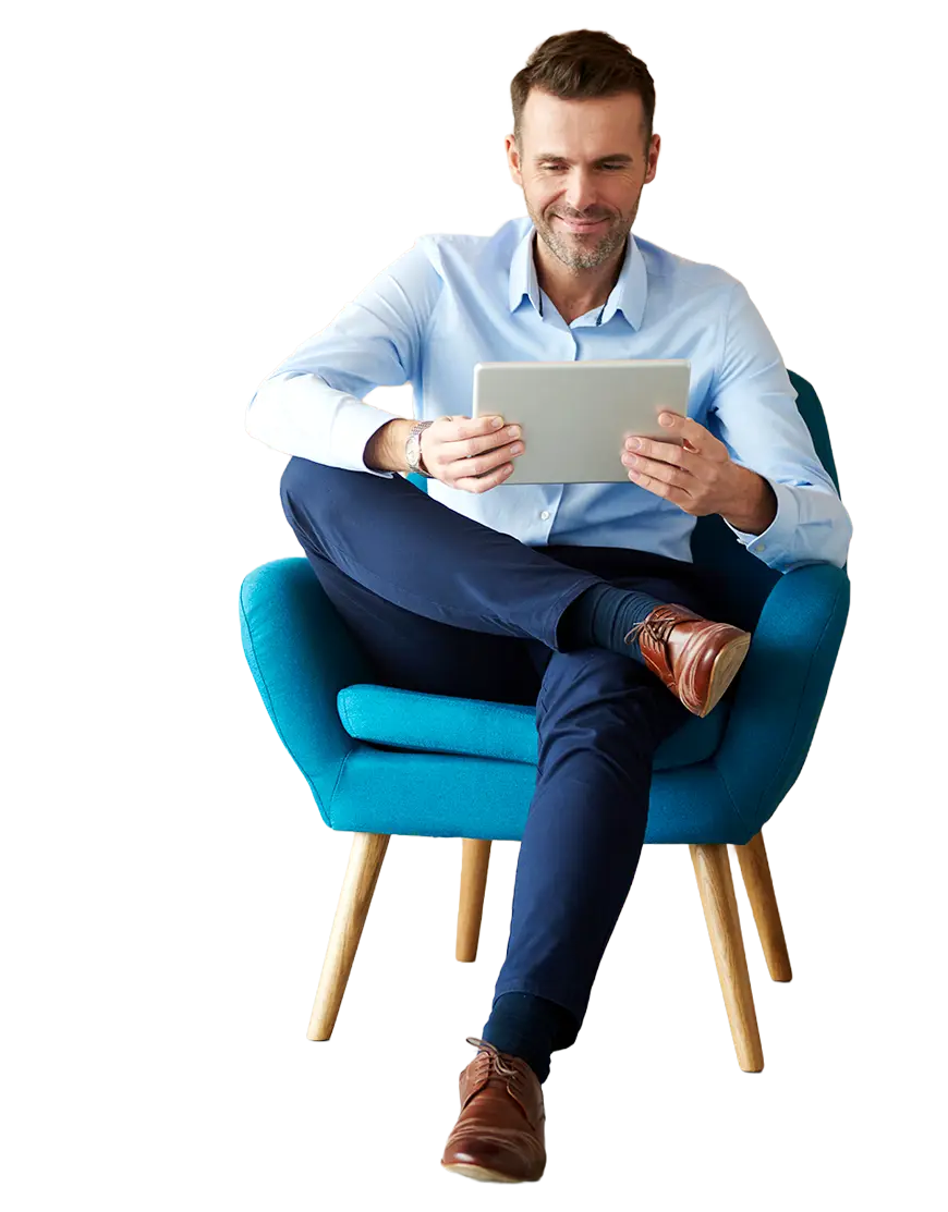 Man sitting on a chair looking at a tablet.